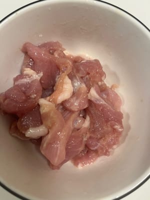 Cortar la carne magra en rodajas, mezclar con maicena, salsa de soja, un poco de sal y pimienta blanca, y finalmente agregar aceite y marinar durante 15 minutos.