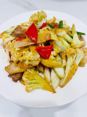 Lave la olla, vierta la coliflor y la carne que se sacaron anteriormente, agregue el pimiento rojo, la cebolla verde y los segmentos de cebolleta y saltee hasta que estén cocidos, agregue 1 cucharada de salsa de soja ligera, 1 cucharada de salsa de ostras y un poco de azúcar blanca para sazonar.