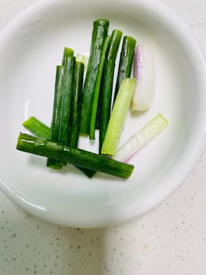 Picar el pimiento rojo en trozos, cortar la cebolla verde en secciones, cortar el ajo, cortar el jengibre en rodajas, cortar la cebolla en trozos y cortar la cebolla verde en secciones para usar más adelante.