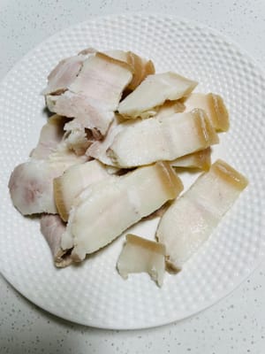 Cortar la panceta de cerdo blanqueada en rodajas finas y reservar.
