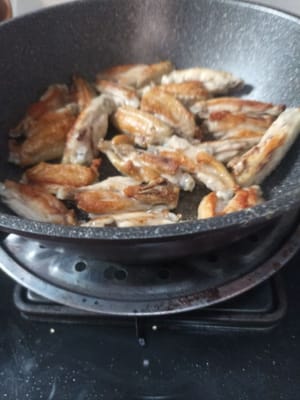 Retournez, et ainsi de suite, retournez les ailes de poulet jusqu'à ce qu'elles soient cuites, réduisez le feu car ici je vais faire sauter la sauce teriyaki, donc je n'éteins pas le feu, puis soulevez les ailes de poulet et placez-les sur une assiette