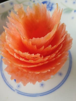 Doblar 150 gramos de rodajas de zanahoria en una flor de zanahoria y reservar.