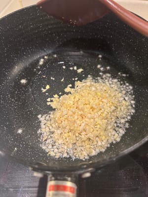 utilizzando l'olio di pepe di Sichuan, soffriggere in padella l'aglio e lo zenzero tritati