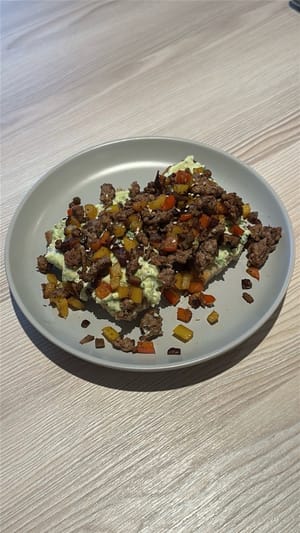 Zum Schluss die Guacamole auf Toast anrichten, dann das Taco-Rindfleisch und genießen!