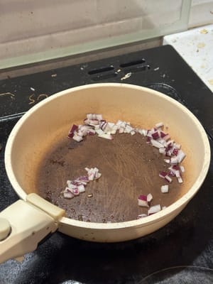 In einer erhitzten Pfanne die gehackte Zwiebel braten, bis sie weich ist