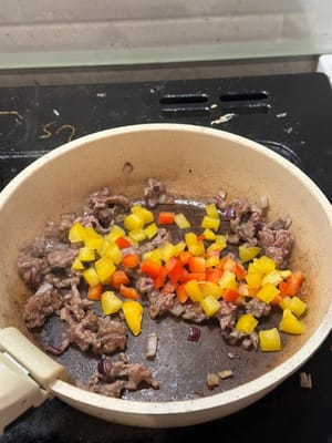 Paprika hinzufügen und mit Salz, schwarzem Pfeffer, Paprika und Kreuzkümmel anbraten