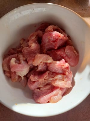 Lavar la carne de cerdo y cortarla en rodajas finas y longitudinales. Marinarla con 1/2 cucharadita de salsa de soja, 1 cucharada de harina de tapioca y 1/2 cucharadita de aceite.