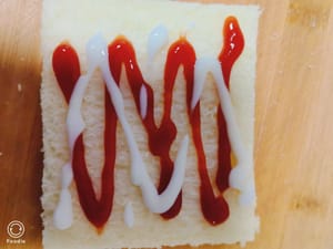 Togliete la crosta dal pane tostato, aggiungete un po' di ketchup e condimento per l'insalata e guarnite con fette di cetriolo.