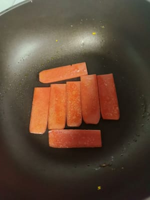 Spennellare una padella con un filo d'olio, friggere un uovo, quindi friggere alcune fette di prosciutto finché entrambi i lati non saranno leggermente dorati.