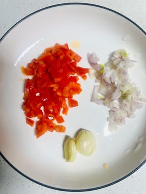 Zwei weitere Knoblauchzehen zerdrücken, die Chilischoten fein hacken und die Schalotten fein hacken.