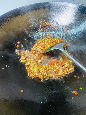 Anbraten, um das rote Öl freizusetzen: Einen Löffel Pixian-Chilibohnenpaste in die Mitte des Topfes geben, anbraten, bis das rote Öl austritt, dann gleichmäßig mit dem Hackfleisch anbraten und einen Löffel dunkle Sojasauce für die Farbe hinzufügen.