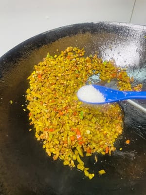 Eingelegte grüne Bohnen anbraten: Gehackte eingelegte grüne Bohnen hinzufügen und gleichmäßig anbraten. 1 Esslöffel helle Sojasauce, 1 Esslöffel Austernsauce, 1 Esslöffel Zucker zur Geschmacksverstärkung und 1 Esslöffel Salz nach Geschmack hinzufügen (vorher abschmecken und bei Bedarf mehr hinzufügen).