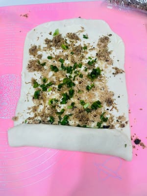 卷面皮
把涂好料的面皮卷成5cm宽的条,卷的时候两边和最后都要收紧,不然烤的时候会变形。再用手轻轻拍压一下,以便馅料更容易贴合。