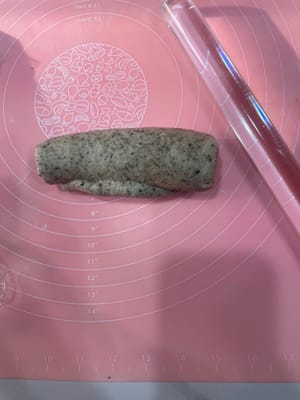 Take a rested dough ball, gently flatten it to release the air, roll it out into a long strip with a rolling pin, and roll it up; roll it out again, roll it up again, and place it vertically into a loaf pan.

Repeat this process for all three loaves, placing them one by one into the loaf pan.