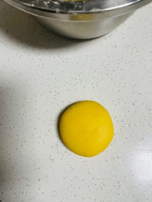 Ambil sedikit adonan, bulatkan dan tekan perlahan dengan telapak tangan hingga membentuk panekuk tipis (ketebalan 1-1,5 cm, jangan terlalu datar agar tidak hancur).
Jika suka isian yang encer, bisa diisi dengan pasta kacang merah, pasta talas, dll. sebelum ditekan.