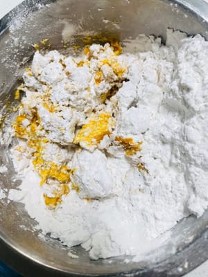 Masukkan 200 gr tepung beras ketan dan 50 gr gula ke dalam bubur labu, aduk hingga menggumpal terlebih dahulu, lalu uleni hingga menjadi adonan yang tidak lengket dan keras (bila terlalu kering, tambahkan sedikit bubur labu, jika terlalu lengket, tambahkan tepung beras ketan).