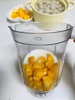 Die Hälfte der Mangostücke, Milch und Zucker in einen Mixer geben und zu einem Mango-Milchshake mixen (die Hälfte der Mango für die Dekoration aufbewahren).
(Da die Mangos, die ich gekauft habe, süß genug waren, habe ich selbst keinen Zucker hinzugefügt.)