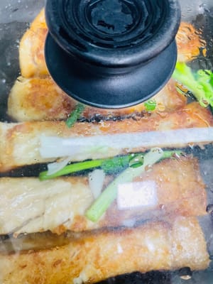 Questo metodo consente di friggere prima qualsiasi lato. Io rosolo la pancia del pesce su tutti e quattro i lati per 1 minuto ciascuno per farla rapprendere, poi copro e la lascio sobbollire a fuoco medio-basso per 1 minuto (spruzzo l'olio sul pesce prima di girarlo), apro il coperchio e scuoto delicatamente la padella per muovere leggermente il pesce. A questo punto, l'amido di mais ha fatto effetto, quindi si è formato uno strato protettivo tra la pelle del pesce e la padella, così puoi muovere il pesce scuotendolo delicatamente. Aggiungi i cipollotti nell'ultimo minuto di frittura e copri per 1 minuto per aumentare l'aroma.