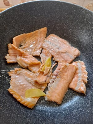 Freír las espinas del salmón, añadir el jengibre y freír hasta que se doren.