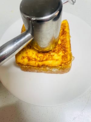 Pour donner forme au pain grillé, déposez-le sur une assiette, puis, à l’aide d’une cuillère ou d’un maillet à viande, formez une cavité au centre pour faciliter le remplissage avec le lait. Versez ensuite une quantité suffisante de lait concentré sucré.