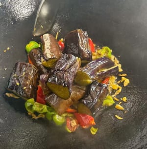 tumis paprika hijau dan merah hingga merata, kemudian masukkan terong yang sudah diolah ke dalam wajan.