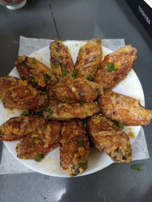 Angkat dan taburi daun bawang kepak ayam telur asin siap di sajikan