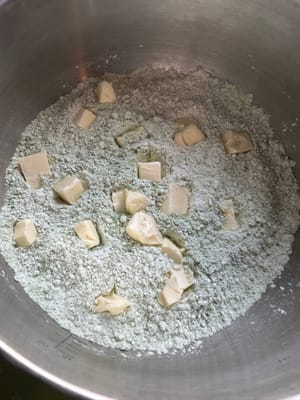 Ajoutez ensuite le beurre coupé en dés aux ingrédients secs.