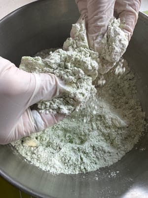 將牛油揉搓進麵粉中，直到形成小塊狀。揉捏麵粉時，麵團應該能捏成形狀，但鬆開後會立即變形。此外，請務必快速完成這些步驟，因為手部溫度可能會融化牛油，從而影響司康餅的最終效果。