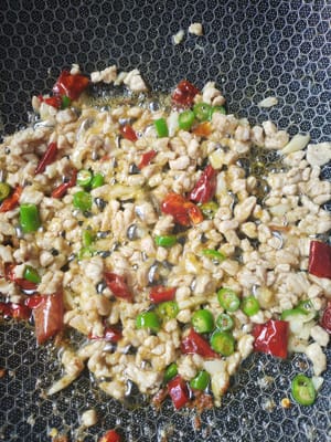 起鍋放油爆炒蒜泥，辣椒，瘦肉丁。