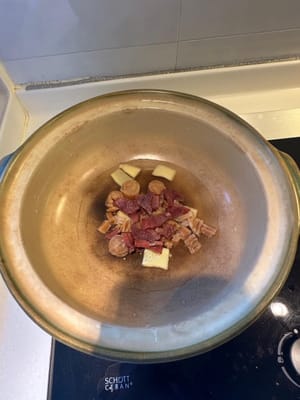 En una olla de barro limpia, colocar el jengibre, las vieiras secas remojadas con agua y el jamón chino como base.