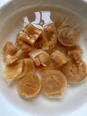Lave bien la vieira seca y déjela en remojo en agua caliente durante unos 10 minutos. Reserve el agua para cocinar el caldo de pollo más tarde.