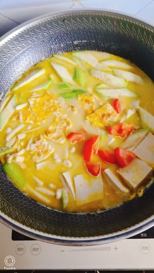 Aggiungere la luffa a fette e i funghi enoki alla zuppa filtrata per esaltarne il sapore, aggiungere le uova tagliate a pezzetti e un pezzo di tofu tenero. Per condire, basta aggiungere un cucchiaio di sale e un po' di pepe, non servono altri condimenti. Cuocere a fuoco vivo per 4-5 minuti e spegnere il fuoco.