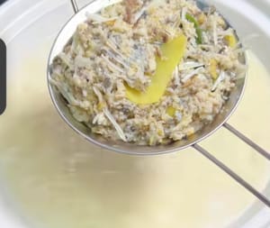 Togliere il pesce dall'acqua e scolarlo in un altro contenitore per eliminare gli ingredienti e le lische.