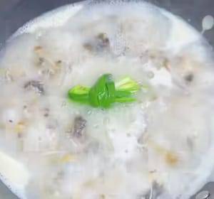 Aggiungere qualche fettina di zenzero e un ciuffo di cipollotto per eliminare l'odore di pesce, coprire e cuocere a fuoco medio per 8 minuti.