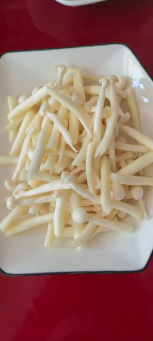 Lavare i funghi enoki con acqua pulita e metterli da parte
