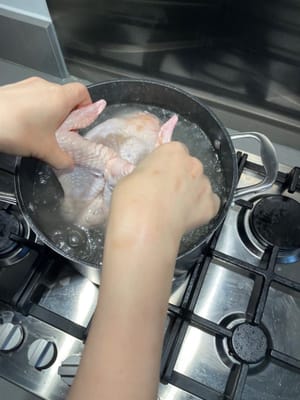 分鐘後，把雞浸入滾水中，然後提起。