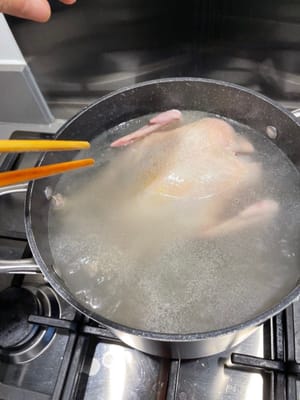 第三次提起雞隻後，便可完全浸雞入水中，雞胸朝下。