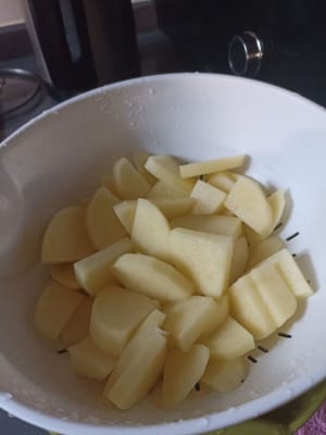 Tagliare, lavare e scolare le patate.