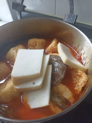 Después de 5-6 minutos, añadimos los camarones. Solo uso 4 camarones, amigos. Añadimos el tofu frito cortado en croquetas y volvemos a cocinar hasta que hierva durante 2-3 minutos.