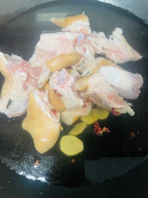 Wash the pig's feet and cut them into small pieces. Put them in a pot with cold water, add ginger slices, cooking wine and peppercorns, blanch them, then remove them and drain them for later use.