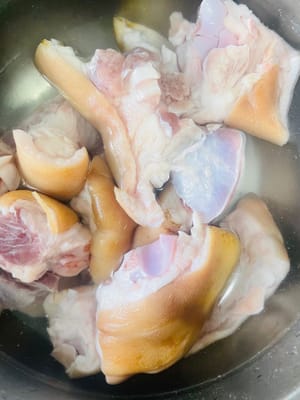Wash the pig's feet and cut them into small pieces. Put them in a pot with cold water, add ginger slices and cooking wine, blanch them, then remove them and drain them.