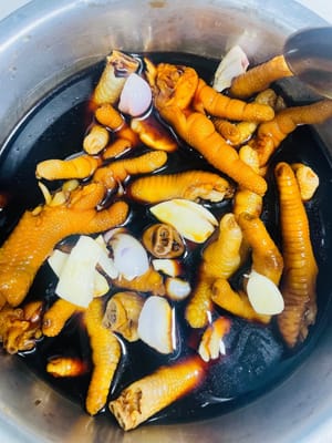 Coloque las patas de pollo frías en la salsa de vinagre previamente preparada y enfriada, asegurándose de que queden completamente sumergidas. Déjelas reposar toda la noche. Si prefiere el sabor a ajo y cebolla, añada una pizca de ajo y cebolla durante el remojo. Si su recipiente es grande, añada la salsa de vinagre en una proporción 1:1:1 de vinagre dulce, salsa de soja ligera y agua para asegurar que las patas de pollo queden completamente sumergidas.