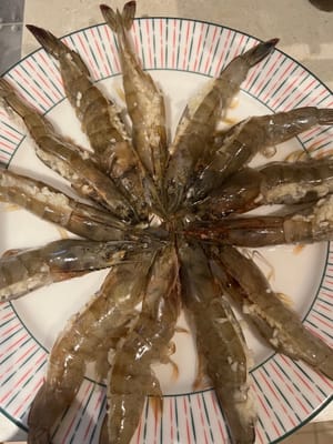 Den gehackten Knoblauch auf die offene Seite der Garnelen geben