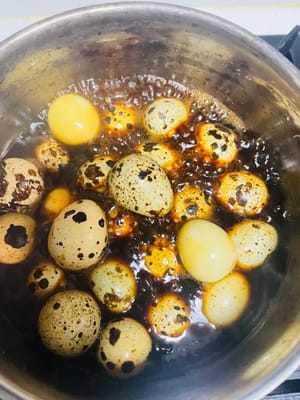 En una olla pequeña, coloque los huevos de codorniz, añada salsa de soja, salsa de ostras, polvo de cinco especias, salsa de soja oscura y 100 ml de agua (el agua debe cubrir la mitad de los huevos). Lleve a ebullición a fuego alto y luego cocine a fuego lento durante 5 minutos, removiendo entre cada cocción. Después de apagar el fuego, deje los huevos de codorniz en la marinada durante 10 minutos para que estén más sabrosos.