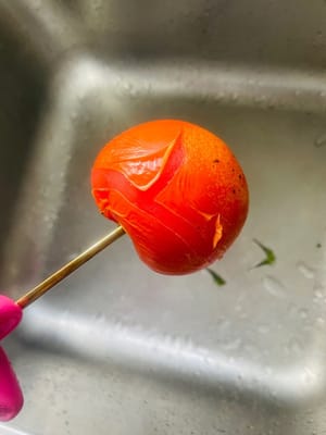 處理番茄:
我偏愛擱煤氣爐上燎一下,皮兒「呲溜」就撕下來了,切薄片備用。你要是懶,用開水燙或直接削皮也成,怎麼省事怎麼來~