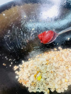 加入醬料酸菜番茄:
把炒好的肉末扒拉到鍋邊,要是油少了就再添點,油夠的話直接下張英池醬,炒出紅油後,把雲南小醬酸菜和切好的番茄倒進去,跟醬料一起翻炒均勻,酸香立刻就出來了~
往鍋裡加適量水,想多嗦點湯就多放些。