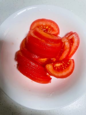 處理番茄:
我偏愛擱煤氣爐上燎一下,皮兒「呲溜」就撕下來了,切薄片備用。你要是懶,用開水燙或直接削皮也成,怎麼省事怎麼來~