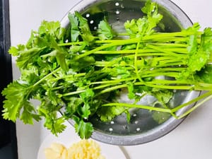 魚を焼いている間に、材料と付け合わせを準備します。
1. ニンニクはみじん切りにするか、そのままにしておきます。ショウガは薄切りにし、ネギは小口切りにします。パクチーと玉ねぎは洗って薄切りにします。

2. その他の付け合わせ（キャベツ、こんにゃく豆腐、豆腐シート、きのこなど）を洗って準備します。