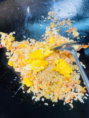 Versare il riso freddo e saltare velocemente fino a quando ogni chicco di riso non sarà ricoperto dal colore del kimchi e diventerà lucido e traslucido. Quindi aggiungere le uova strapazzate e saltare uniformemente con il riso.