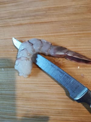 quindi incidere con un coltello il centro del ventre del gambero fino ad arrivare al dorso.
